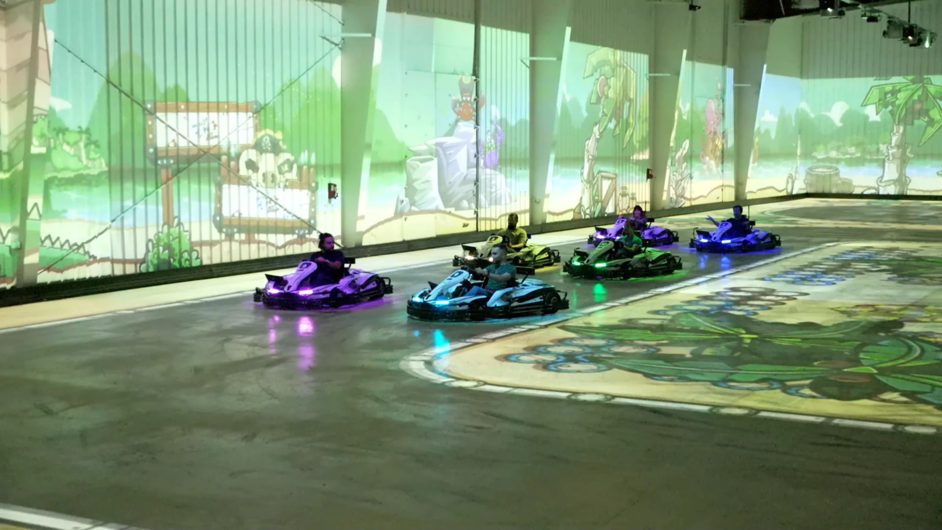 Karts racing side by side on the track projected on the floor at BattleKart Dijon, during La Battle des Régions